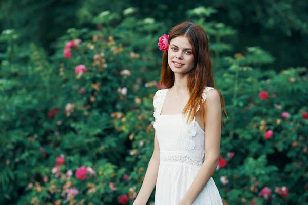 花园里开着玫瑰花的年轻女子 — 图库照片