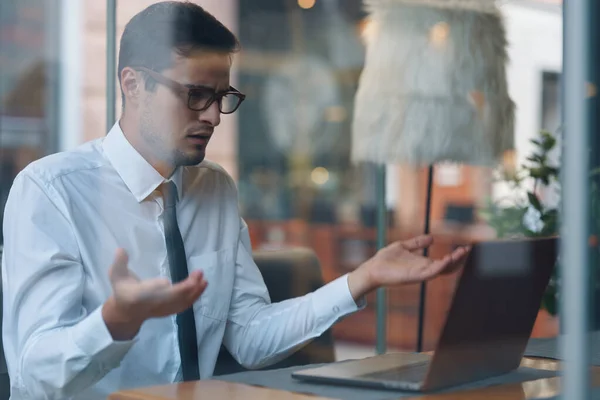 Young  confused businessman with laptop  in the office