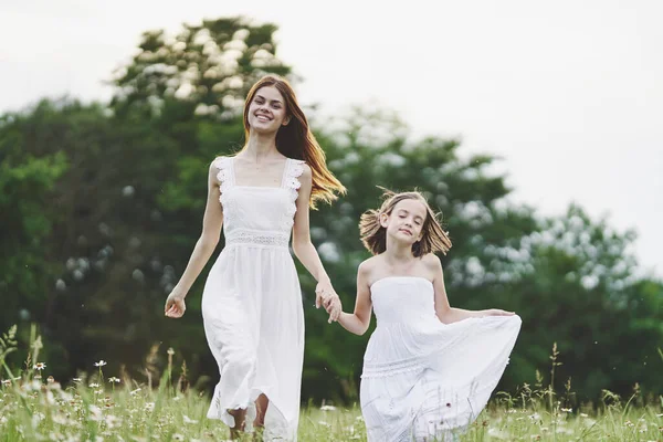 stock image Young mother and her daughter having fun on camomile field