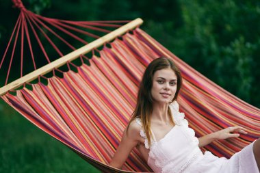Genç ve güzel bir kadın hamakta dinleniyor. 