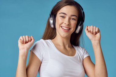Kulaklıklı genç bir kadın müzik dinliyor.