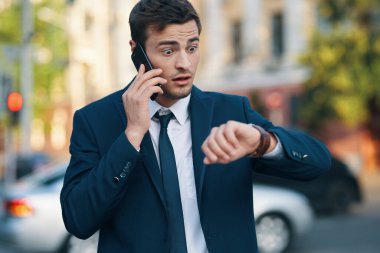 Genç kızgın iş adamı sokakta akıllı telefondan konuşuyor. 