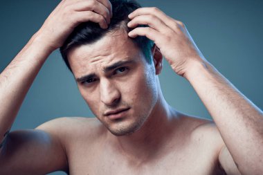 Stüdyo çekimi. Modern saç stili olan genç yakışıklı bir adam stüdyoda poz veriyor. 