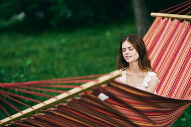 Genç ve güzel bir kadın hamakta dinleniyor.