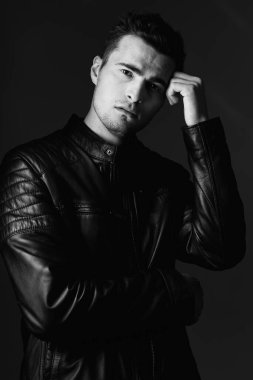 Stüdyoda düşünen yakışıklı bir genç. Siyah beyaz. 