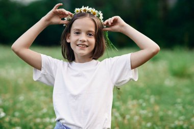 Genç tatlı kız papatya tarlasında eğleniyor.