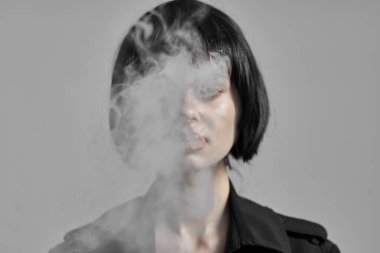 Stüdyoda sigara içen güzel bir kadın. Moda fotoğrafçılığı 