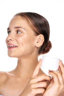 Kremalı güzel bir kadının stüdyo fotoğrafı, izole edilmiş bir arka planda güzellik ürünü.