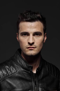 Deri ceketli genç yakışıklı adamın portresi. Stüdyo çekimi. Moda fotoğrafçılığı