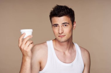 Stüdyo. Güzellik ürünleriyle genç yakışıklı adam.