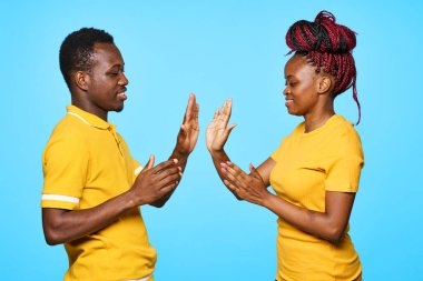 Stüdyoda mavi arka planda poz veren genç ve güzel bir çift