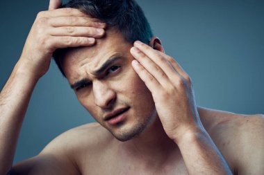 Stüdyo çekimi. Modern saç stili olan genç yakışıklı bir adam stüdyoda poz veriyor. 