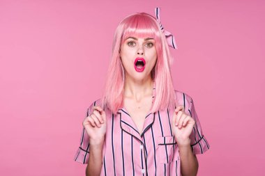 Stüdyoda poz veren pembe peruklu güzel bir kadın. 
