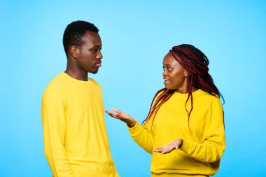 Stüdyoda mavi arka planda poz veren genç ve güzel bir çift