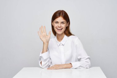 Genç ve güzel bir iş kadını el sallıyor. 