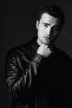 Stüdyo portresindeki genç yakışıklı adam, siyah beyaz. 
