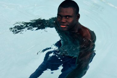 Havuzda poz veren genç yakışıklı adam.