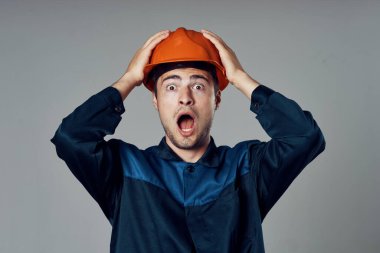 Stüdyo çekimi. Turuncu kasklı sanayi işçisi şok oldu.