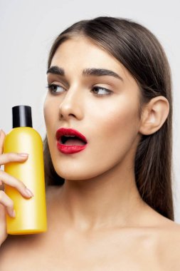 Stüdyoda güzellik ürünüyle güzel bir kadın var. 