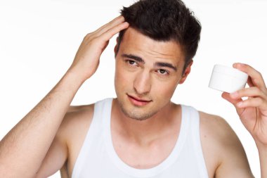 Stüdyo. Genç yakışıklı adam balmumu sürüyor.