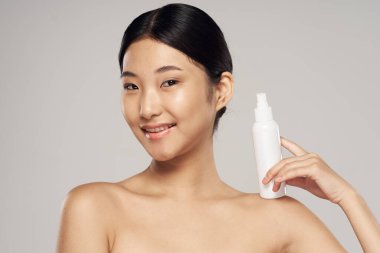 Stüdyo çekimi. Genç Asyalı kadın portresi ve güzellik ürünü.