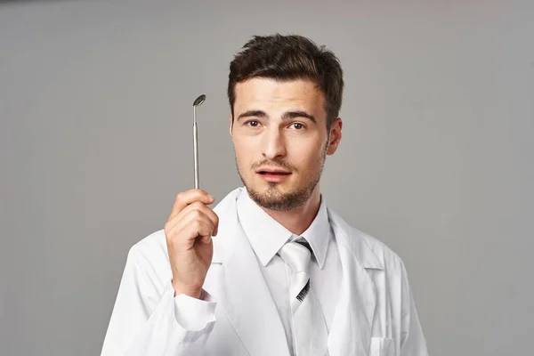 Dentist with medical tool in studio. Medicine, health care