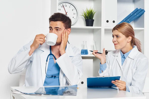 Young doctor drinking coffee  and nurse in hospital