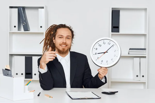 若いビジネスマンが時計を見せるオフィスに座っている — ストック写真
