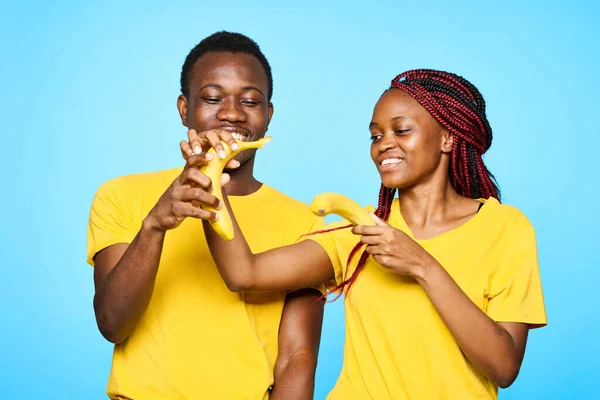 Jovem Casal Bonito Comer Banaas Estúdio Fundo Azul — Fotografia de Stock