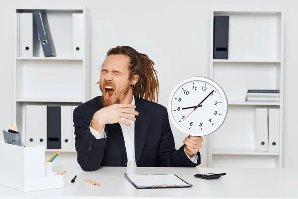 若い怒っているビジネスマンが時計を持ってオフィスに座っている — ストック写真