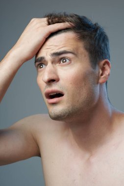 Stüdyo çekimi. Modern saç stili olan genç yakışıklı bir adam stüdyoda poz veriyor. 