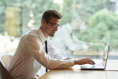 Dizüstü bilgisayarı olan yakışıklı bir iş adamı.