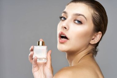 Parfüm şişeli güzel bir kadının portresi. Stüdyo çekimi.  