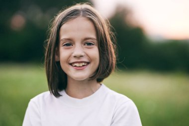 Genç tatlı kız çayırda eğleniyor.