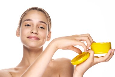 Genç ve güzel bir kadın krem tutuyor. 