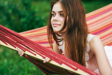 Genç ve güzel bir kadın hamakta dinleniyor.
