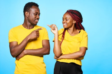 Stüdyoda mavi arka planı gösteren genç ve güzel bir çift.