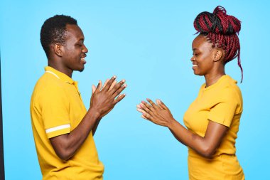 Stüdyoda mavi arka planda poz veren genç ve güzel bir çift