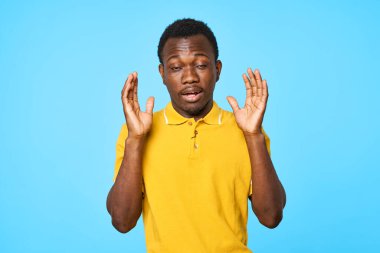 Stüdyoda poz veren yakışıklı genç adam mavi arka planda izole edilmiş.