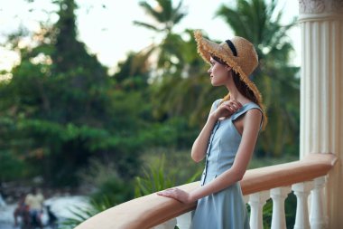   Tropik tatil köyünde hasır şapkalı genç bir kadın. 