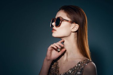 Stüdyoda güneş gözlüğü takan genç ve güzel bir kadın.                                