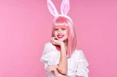 Tavşan kulaklı genç bir kadın stüdyoda poz veriyor. 