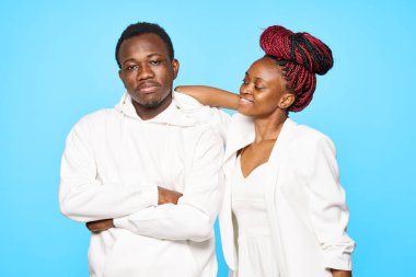 Stüdyoda mavi arka planda poz veren genç ve güzel bir çift