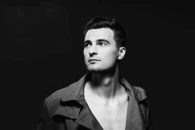 Stüdyoda poz veren yakışıklı bir genç. Siyah ve beyaz  