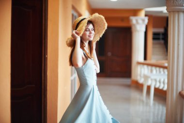   Tropik tatil köyünde hasır şapkalı genç bir kadın. 