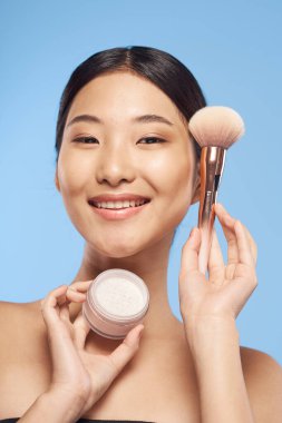 Pudra fırçalı genç Asyalı kadın. 