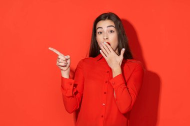 Stüdyo çekimi. Kırmızılı güzel kadın kırmızı arka planda izole edilmiş.