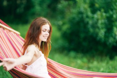 Genç ve güzel bir kadın hamakta dinleniyor. 