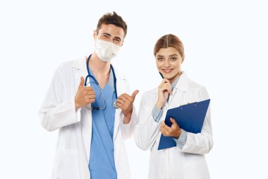 Başparmakları havada genç bir doktor ve stüdyoda hemşirelik yapıyor. Tecrit edilmiş.. 