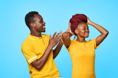 Stüdyoda mavi arka planda poz veren genç ve güzel bir çift